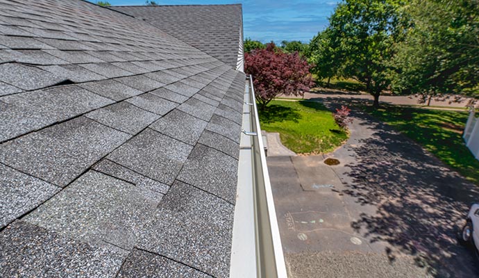 Freshly cleaned gutter system on house roof Freshly cleaned gutter system on house roof
