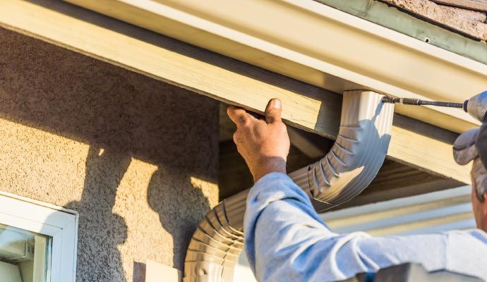Person installing gutter with equipment Person installing gutter with equipment