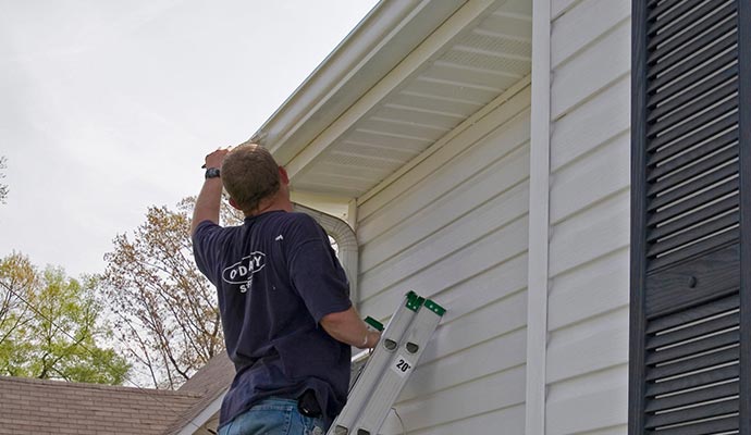 Professional inspecting gutter