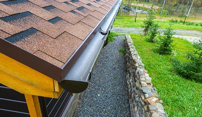 House roof with installed gutter system House roof with installed gutter system