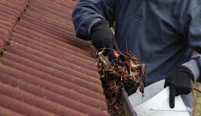 A person cleaning gutter A person cleaning gutter
